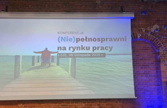 „Ekran projekcyjny na tle ceglanej ściany z wyświetlonym slajdem konferencji pt. ‘(Nie)pełnosprawni na rynku pracy’, Łódź, 6 listopada 2025 r. Na slajdzie widoczna osoba na wózku inwalidzkim na drewnianym pomoście nad wodą.”